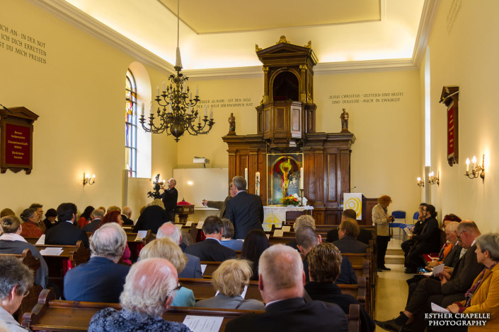 Ansicht Kirche vor Beginn der Zeremonie – im Vordergrund von hinten Psychoanalytiker Harald Picker (im blau-gemusterten Hemd) und der Rektor der Sigmund Freud Privatuniversität Dr. Alfred Pritz (im dunklen Anzug)